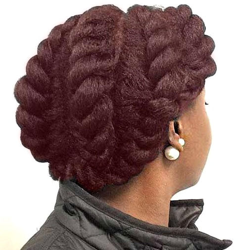 Black model with flat twisted crochet hair on her scalp as she looks away from the camera.
