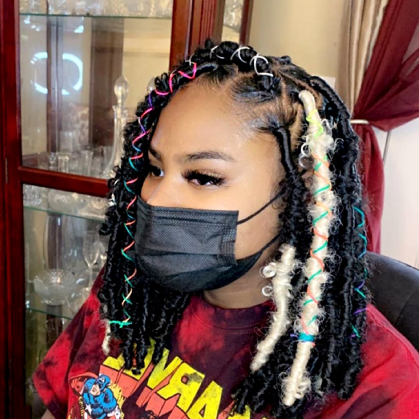 Ebony super model wearing twisted faux loc hair at medium length with accessorized blonde highlighted faux loc with acceossries.