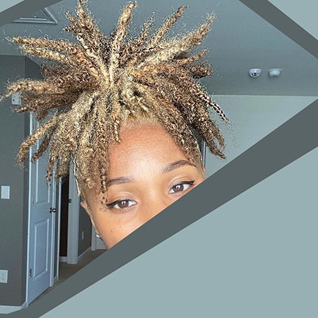 Young black female with wild and kinky blonde faux locs hair.