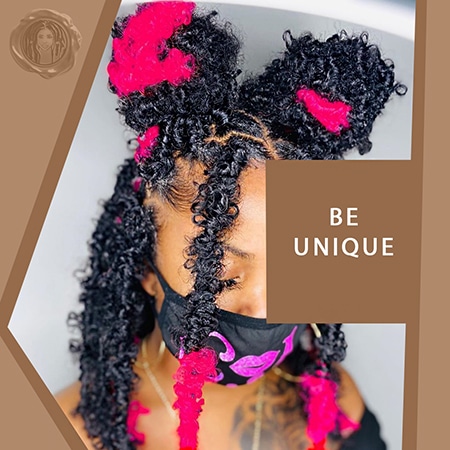 Part of the face of an african queen wearing bright pink butterfly locs that are styled up in space buns.
