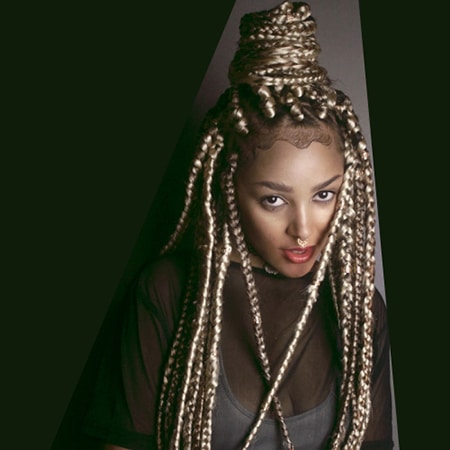 High bun hairstyle of box braids worn by a beautiful black woman model.