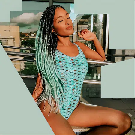 Swim model wearing teal swim suit with long mermaid teal box braid hair color that fades with an ombre shading.